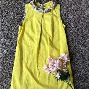 Designed yellow mini dress. Free size. Floral garment buttons in the back